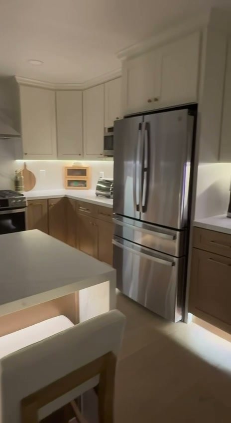 Completed San Ramon kitchen with two-tone cabinetry, stainless-steel refrigerator, and island seating